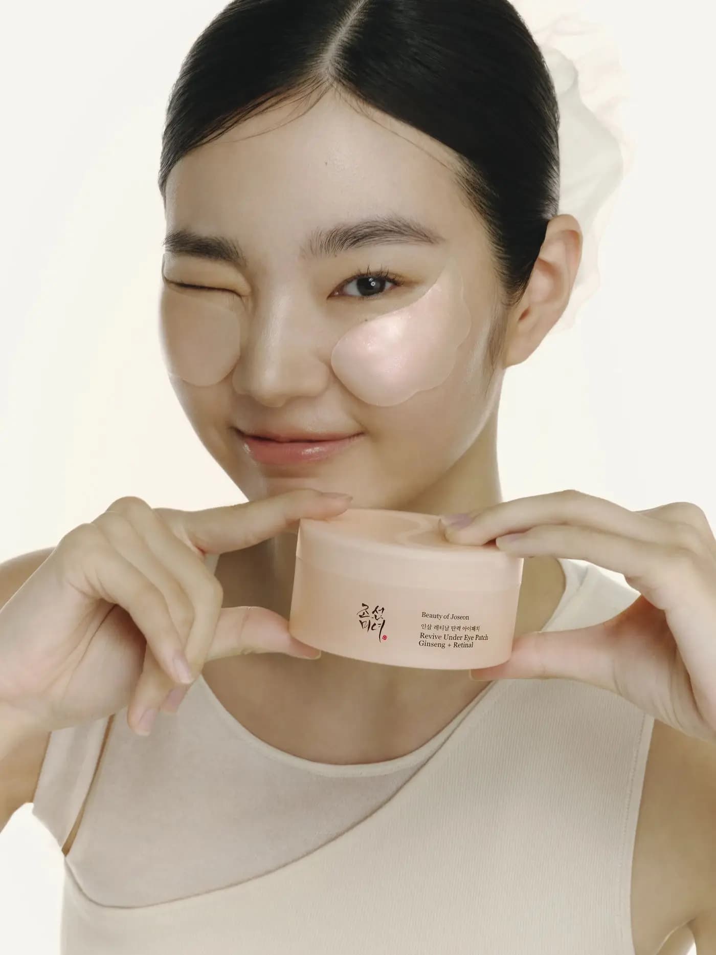 Mujer con parches de contorno de ojos, sosteniendo un tarro de NanaYoung